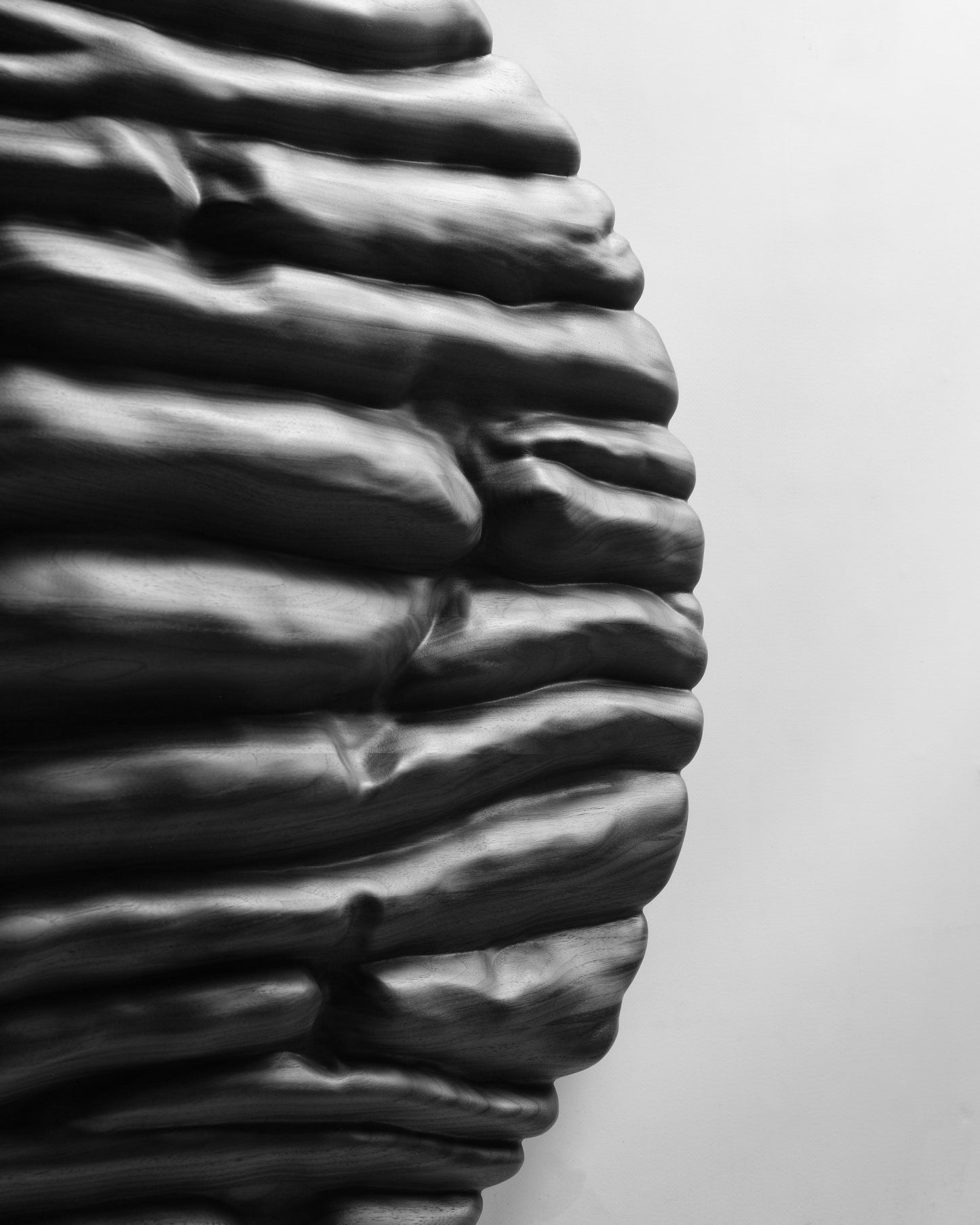 Partial edge view of Strata Black showing the dense rhythm of sculpted horizontal layers