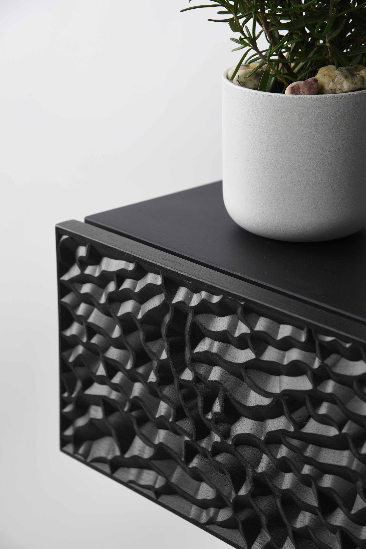 Close up of the carved relief pattern on the total black console drawer front
