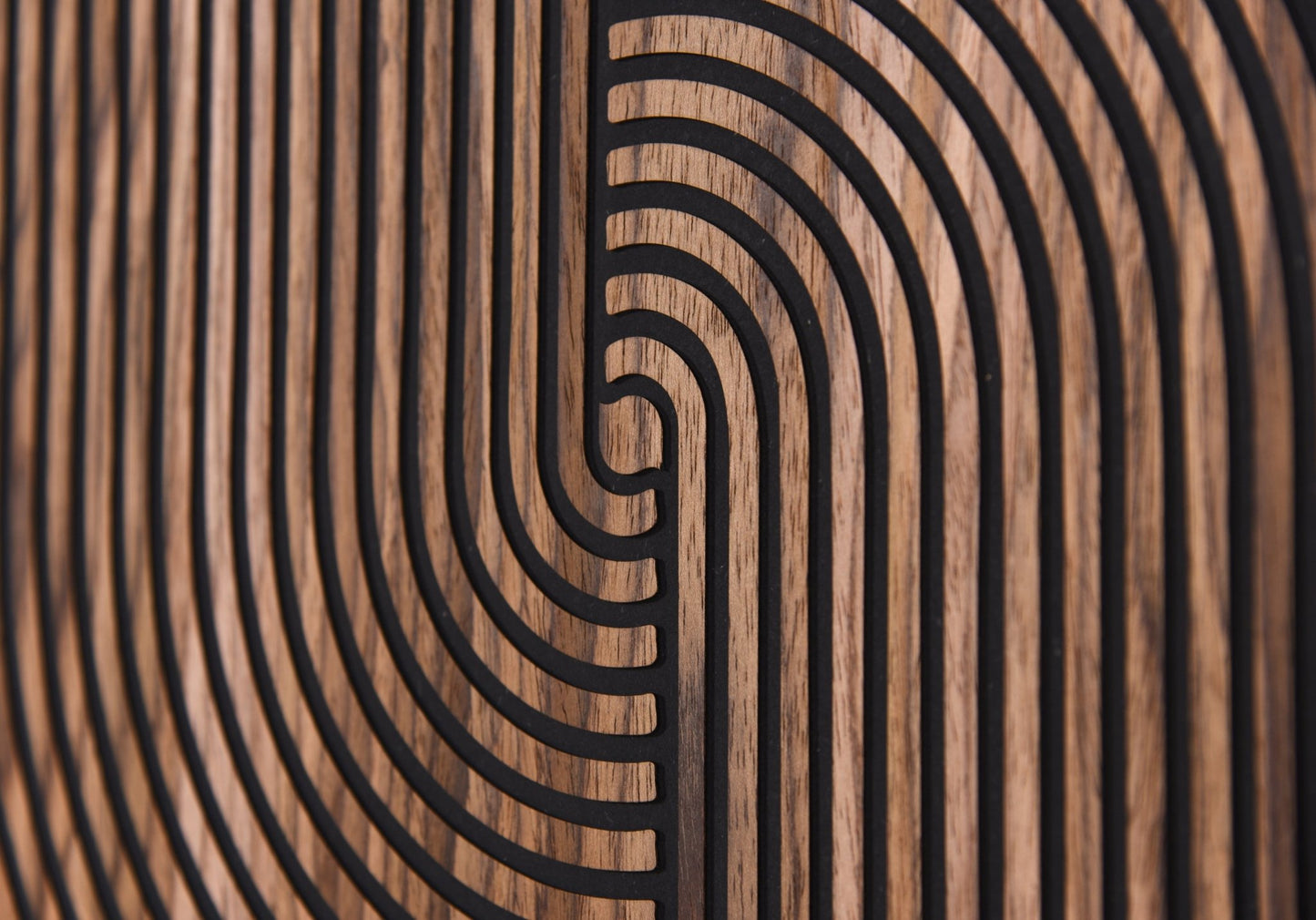Macro detail of carved arc lines and walnut grain on black background