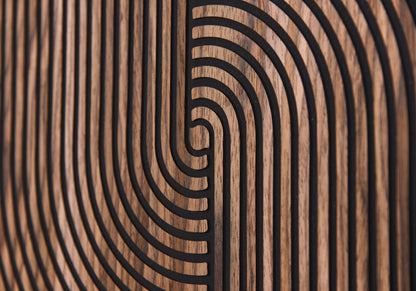 Macro detail of carved arc lines and walnut grain on black background