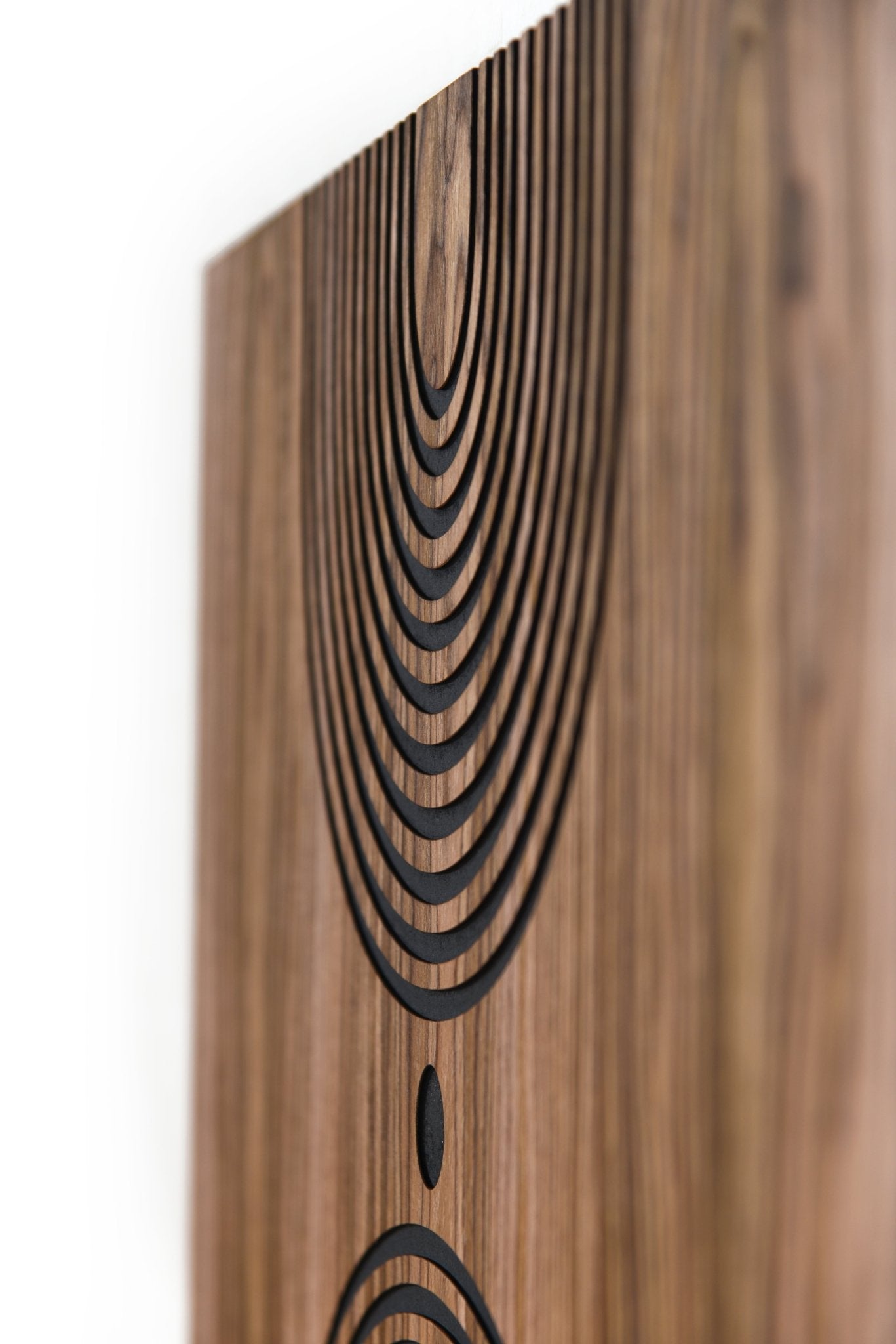 Angled close up of top arc relief on walnut, black grooves and depth