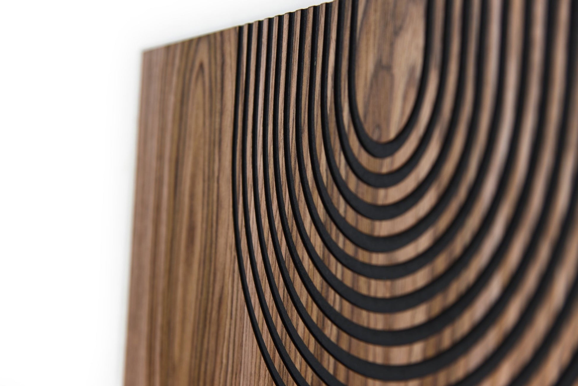 Angled macro of carved arc field, walnut grain and black grooves