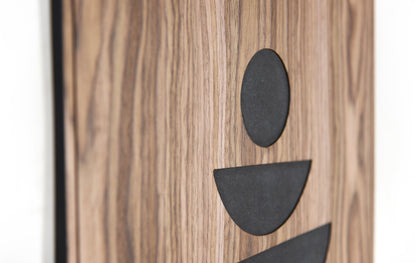 Close up of the minimal figure style shapes in black inlay on walnut
