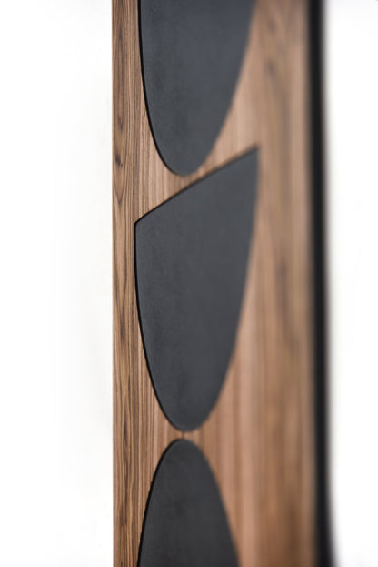 Detail of the black inlay shapes on walnut with visible grain and depth
