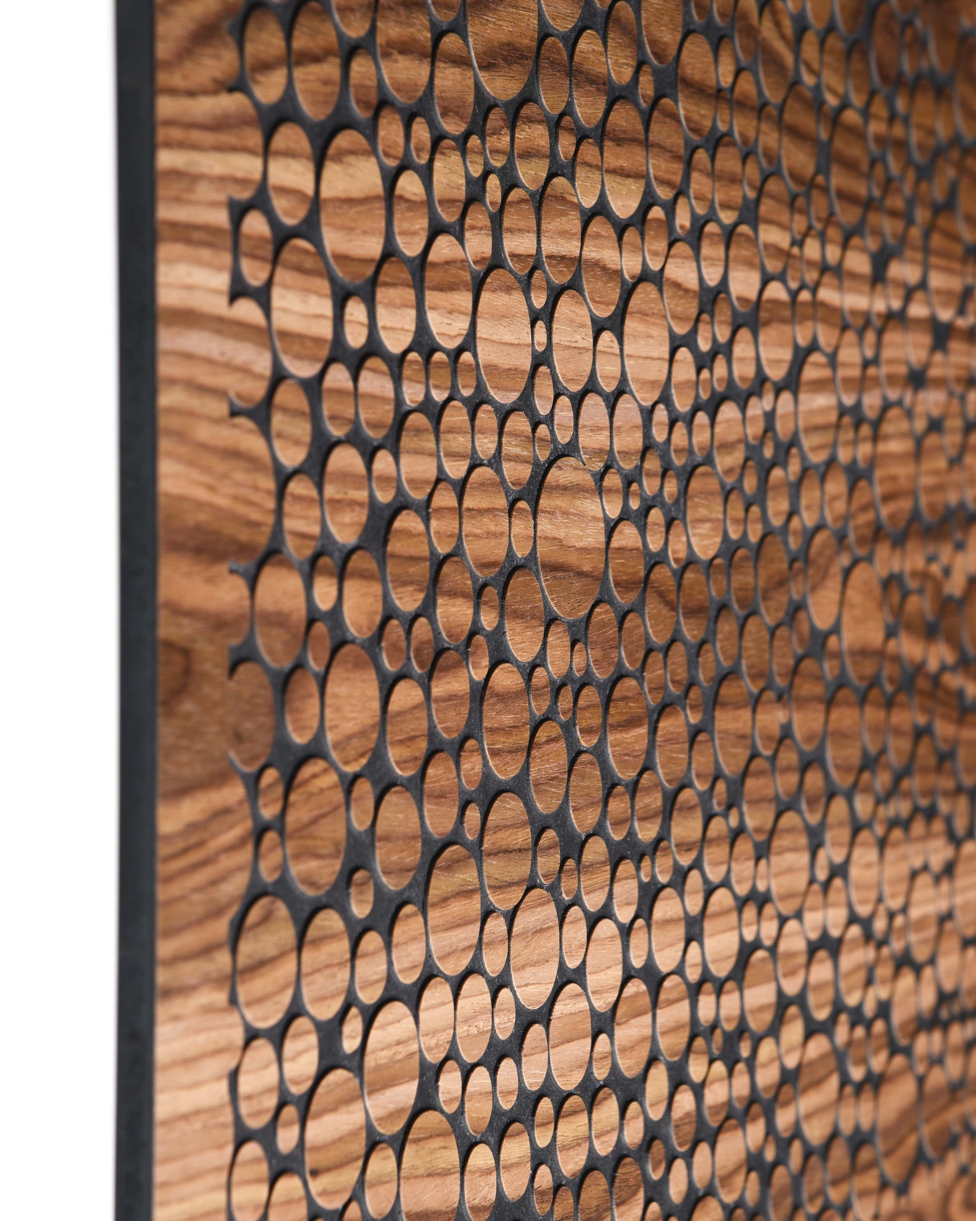 Angled front view of bubble wall panel, carved circle field and walnut surface