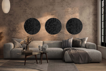 Curated set of three round wall sculptures in iroko and black styled as a gallery composition above a sofa