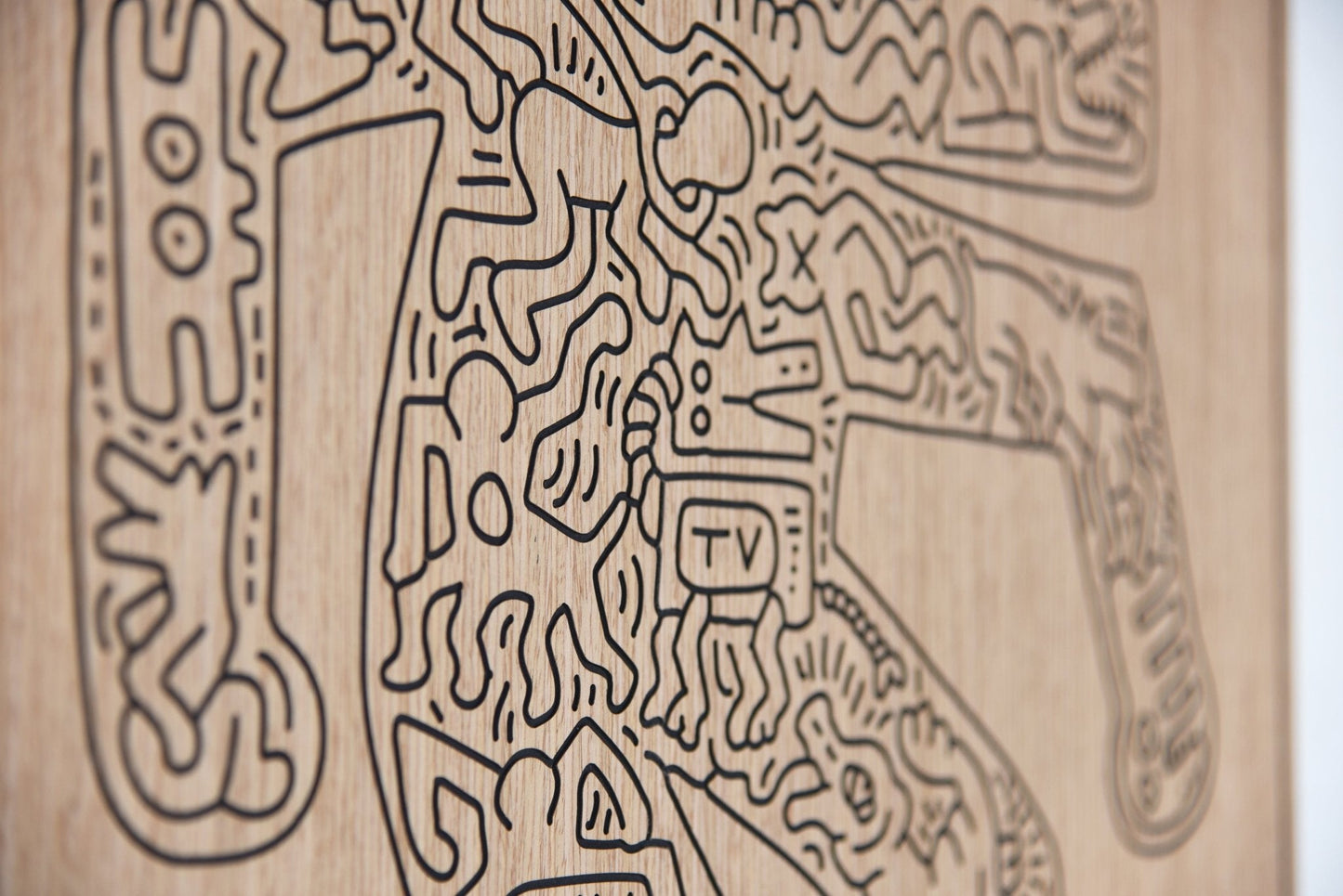 Detail close up of the carved lines and relief depth on the Crocodile Keith Haring oak artwork