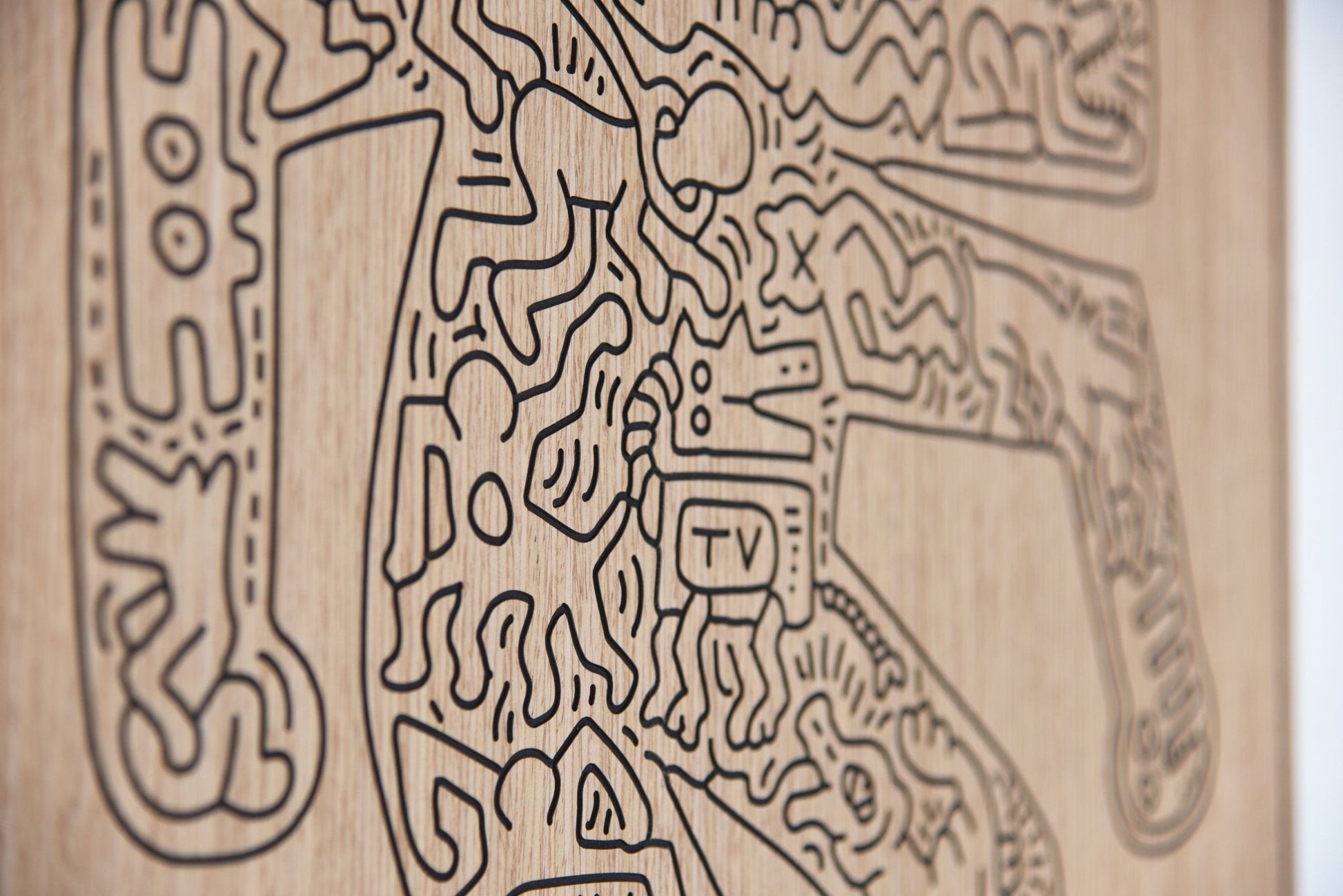 Detail close up of the carved lines and relief depth on the Crocodile Keith Haring oak artwork