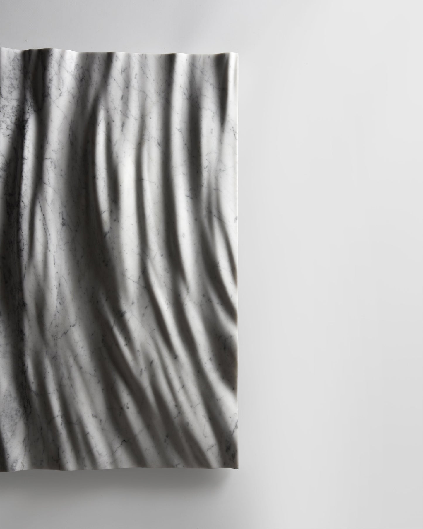 Side profile of the Eternal Carrara marble wall sculpture showing depth and wall projection