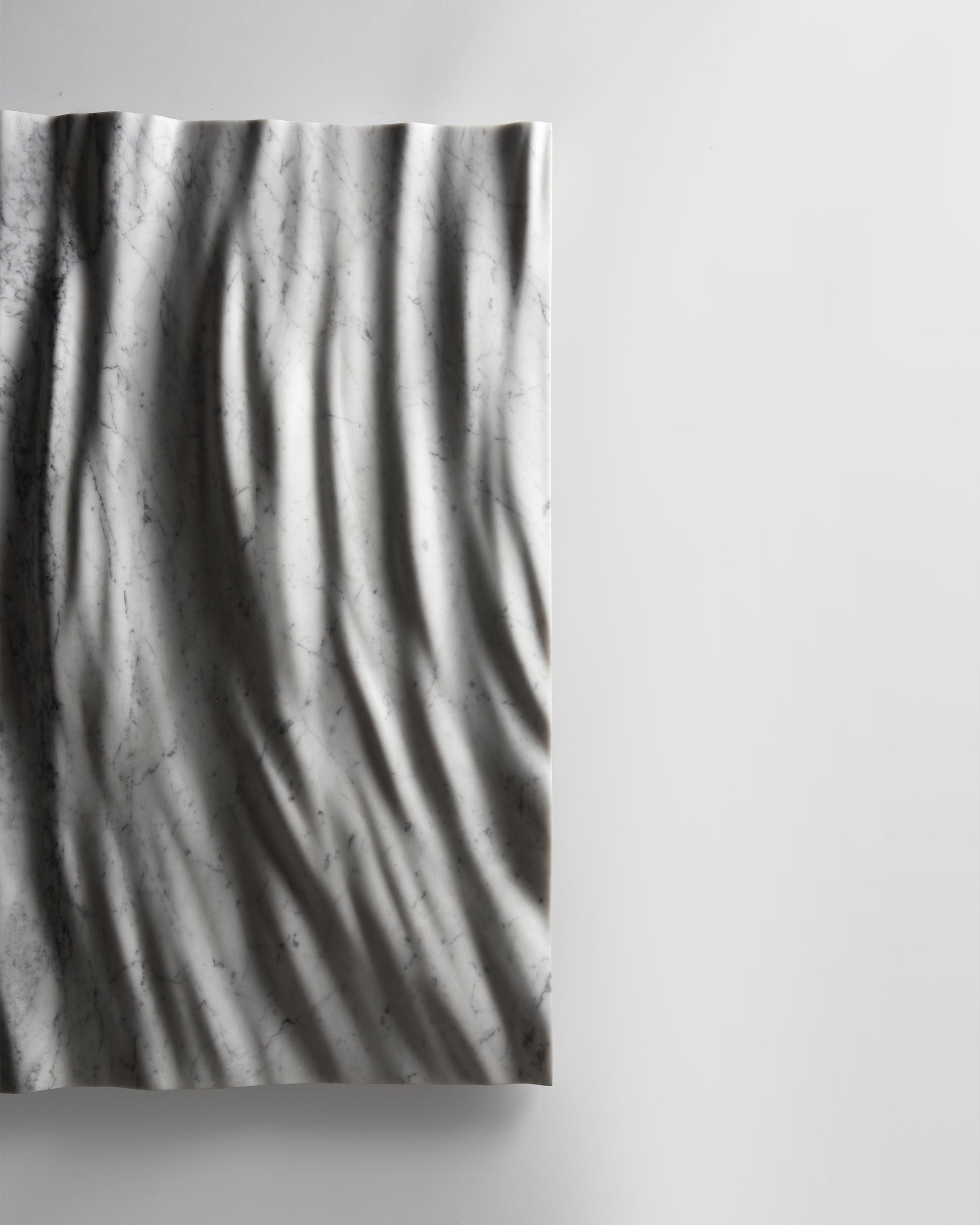 Side profile of the Eternal Carrara marble wall sculpture showing depth and wall projection