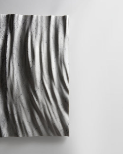 Side profile of the Eternal Carrara marble wall sculpture showing depth and wall projection