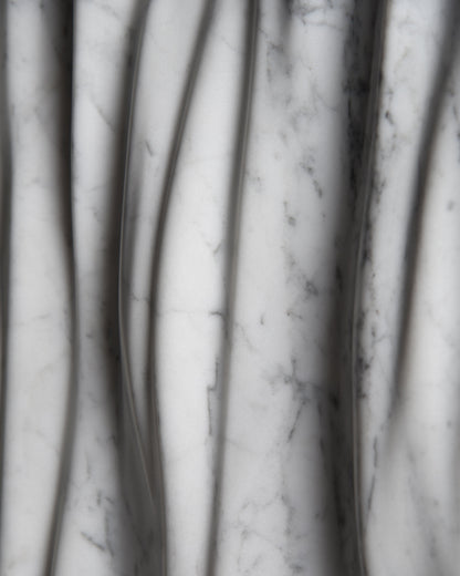 Macro detail of Carrara marble veining and smooth carved folds on the Eternal sculpture