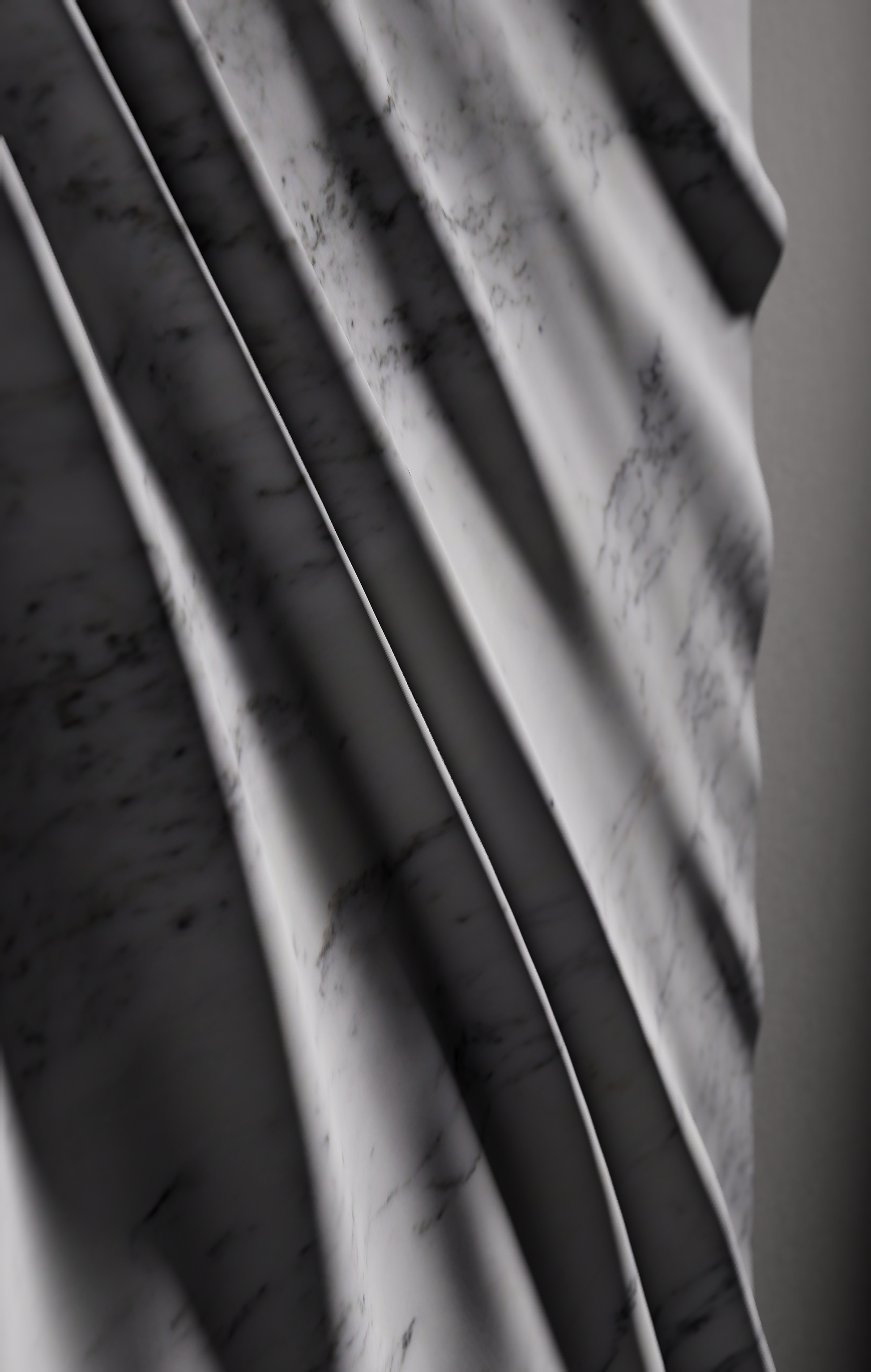 Macro view of draped folds carved in Carrara marble with subtle natural veining