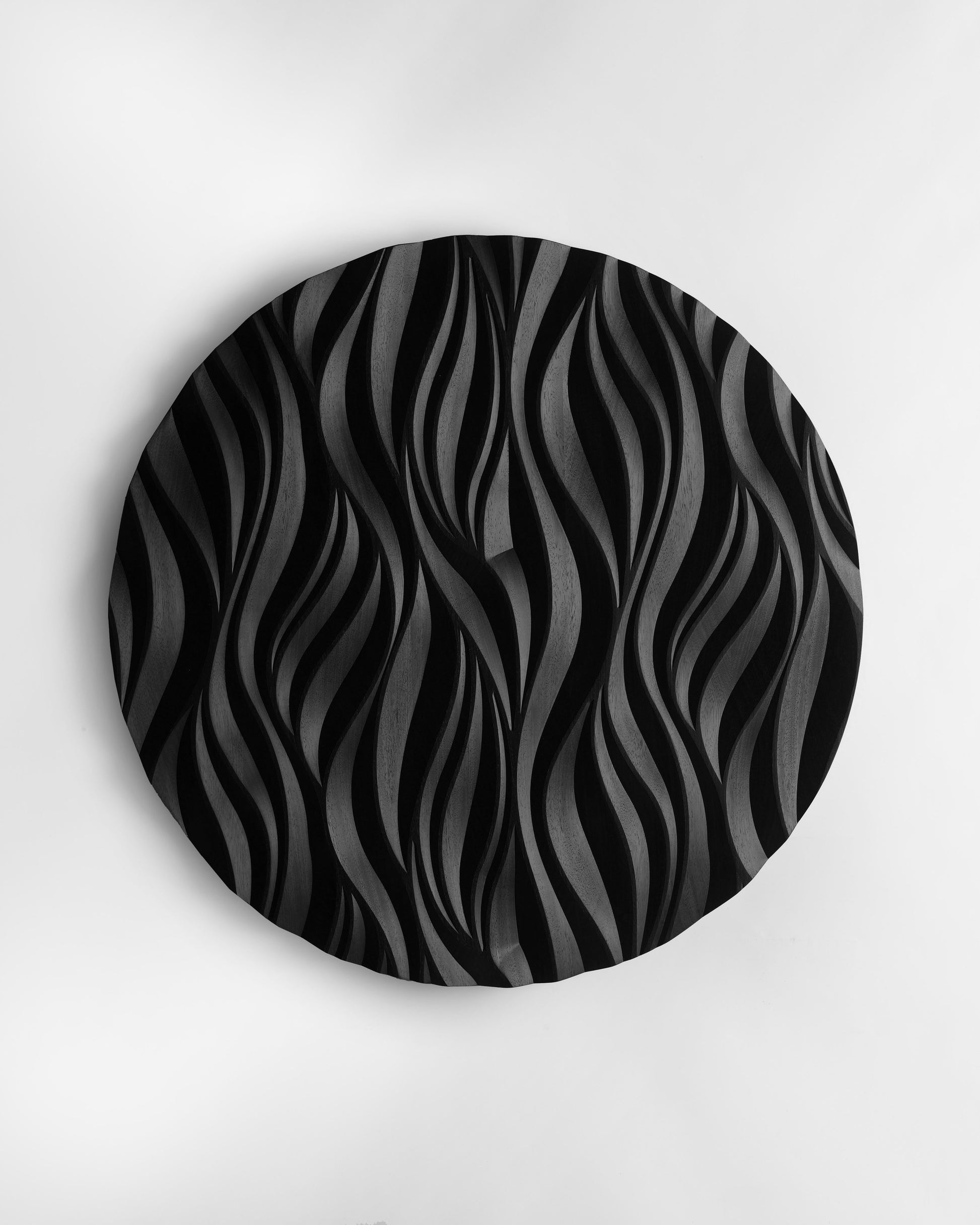 The Fire black round wall sculpture styled in arched niche interior, soft lighting
