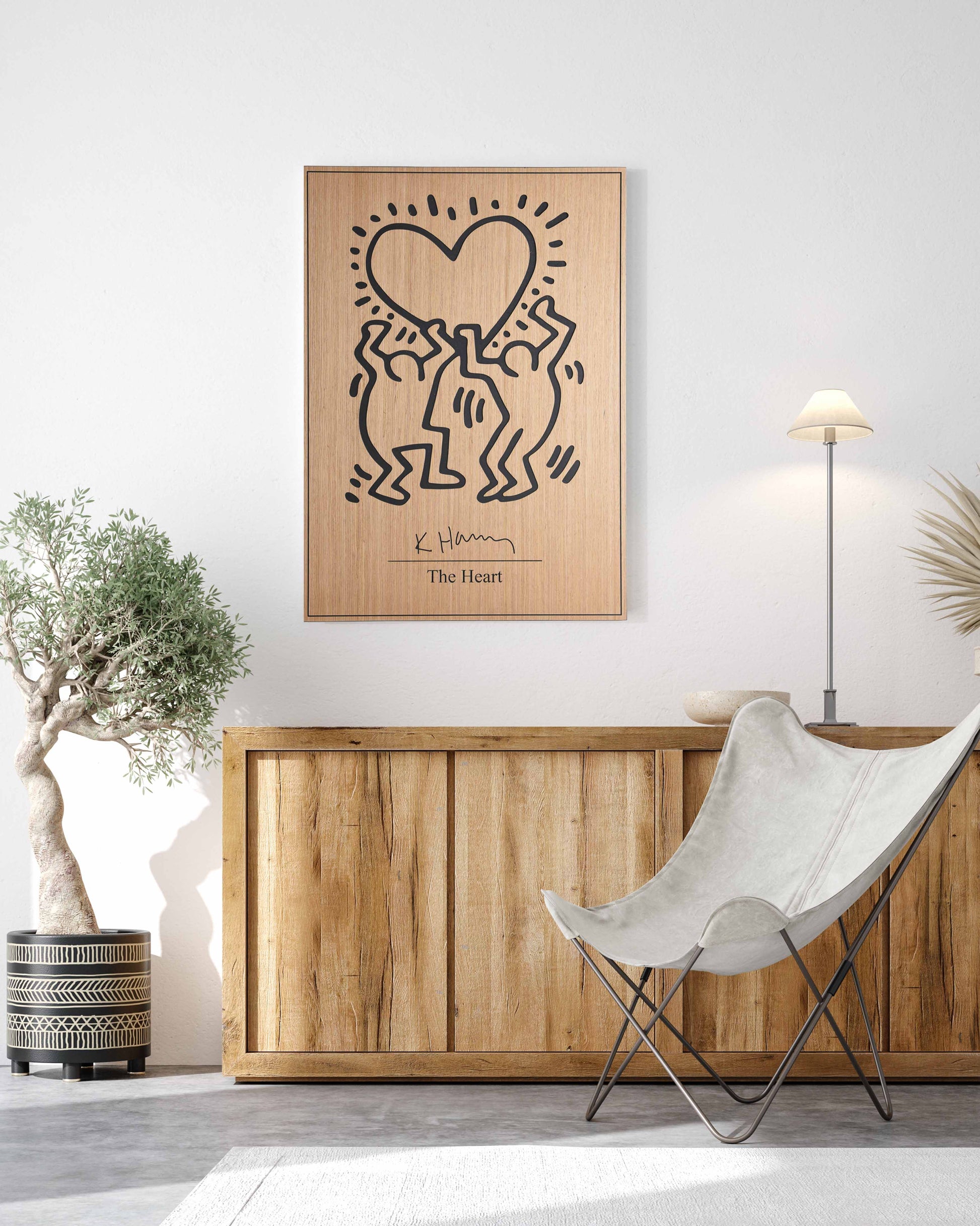 A rectangular oak-and-black wood panel with ‘The Heart’ motif by Kate Harring, hung above a neutral sofa as an eye-catching modern statement.