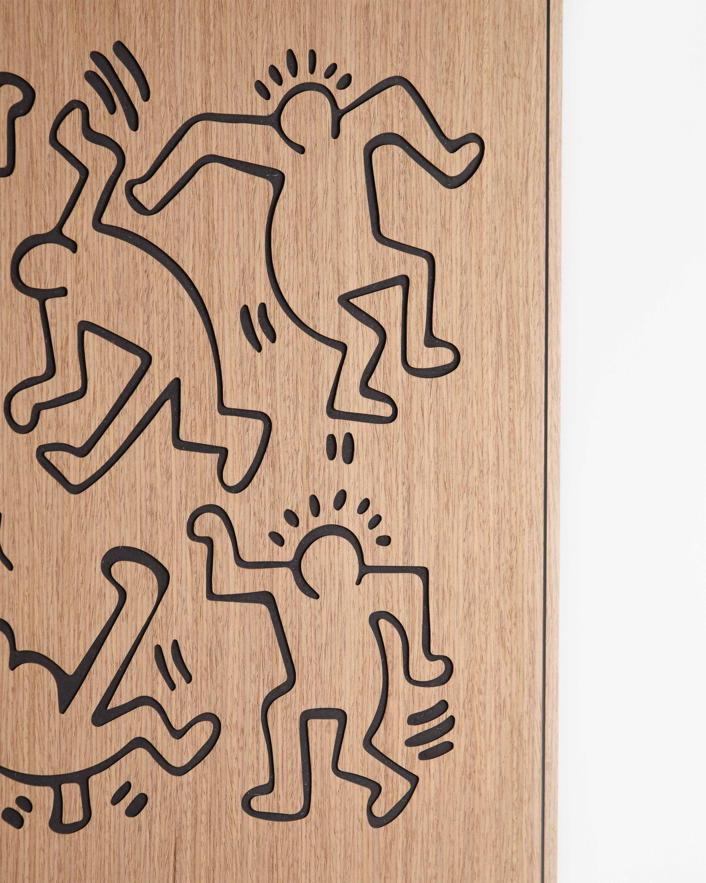 Close-up revealing the crisp outlines of the dancers motif etched into walnut-toned oak with contrasting black sections.