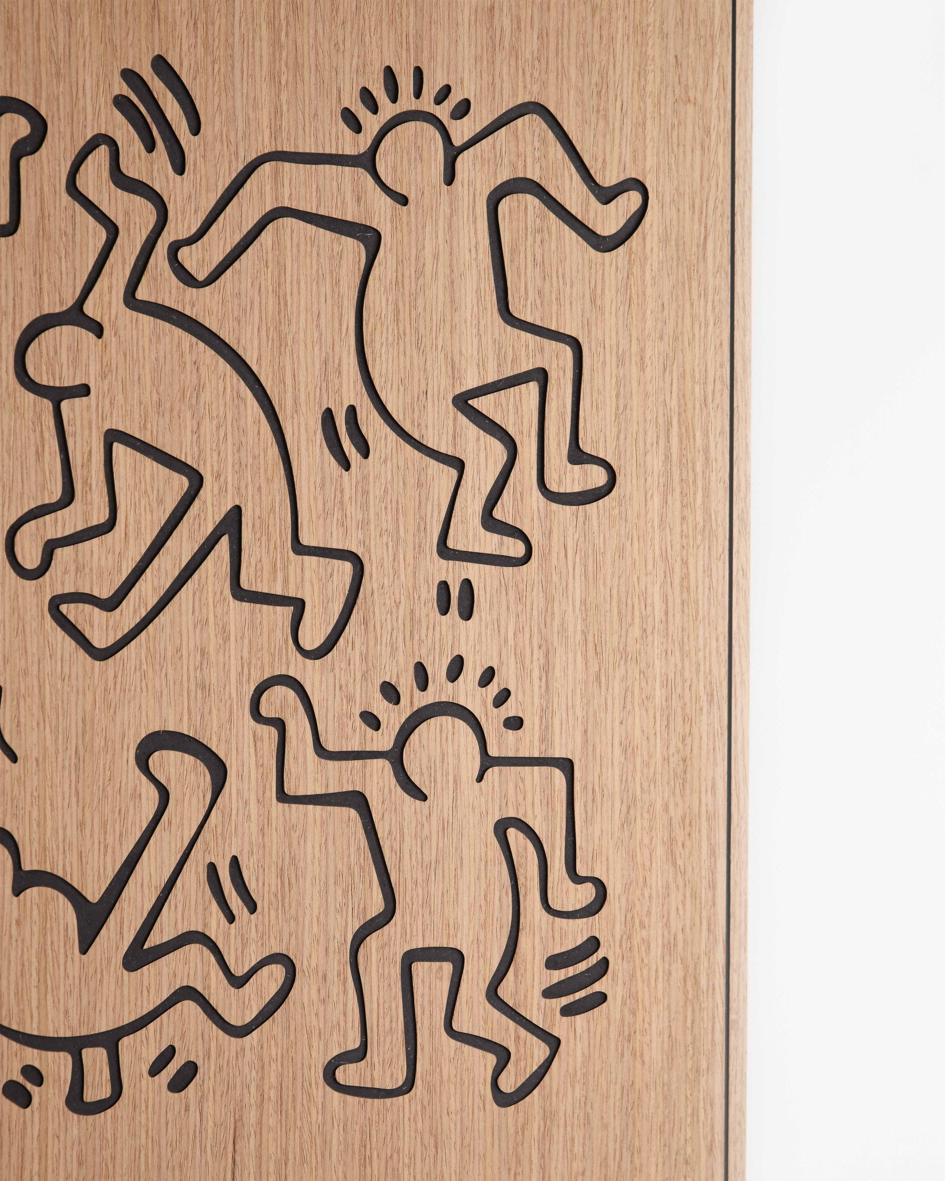 Close-up revealing the crisp outlines of the dancers motif etched into walnut-toned oak with contrasting black sections.
