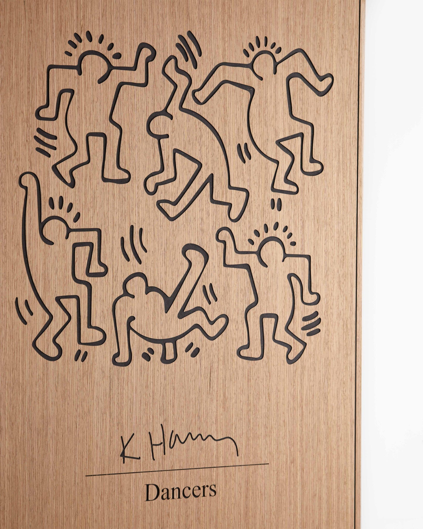 Corner detail focusing on the black accent portion meeting the oak surface, underlining the geometric synergy in Kate Harring’s dancers.