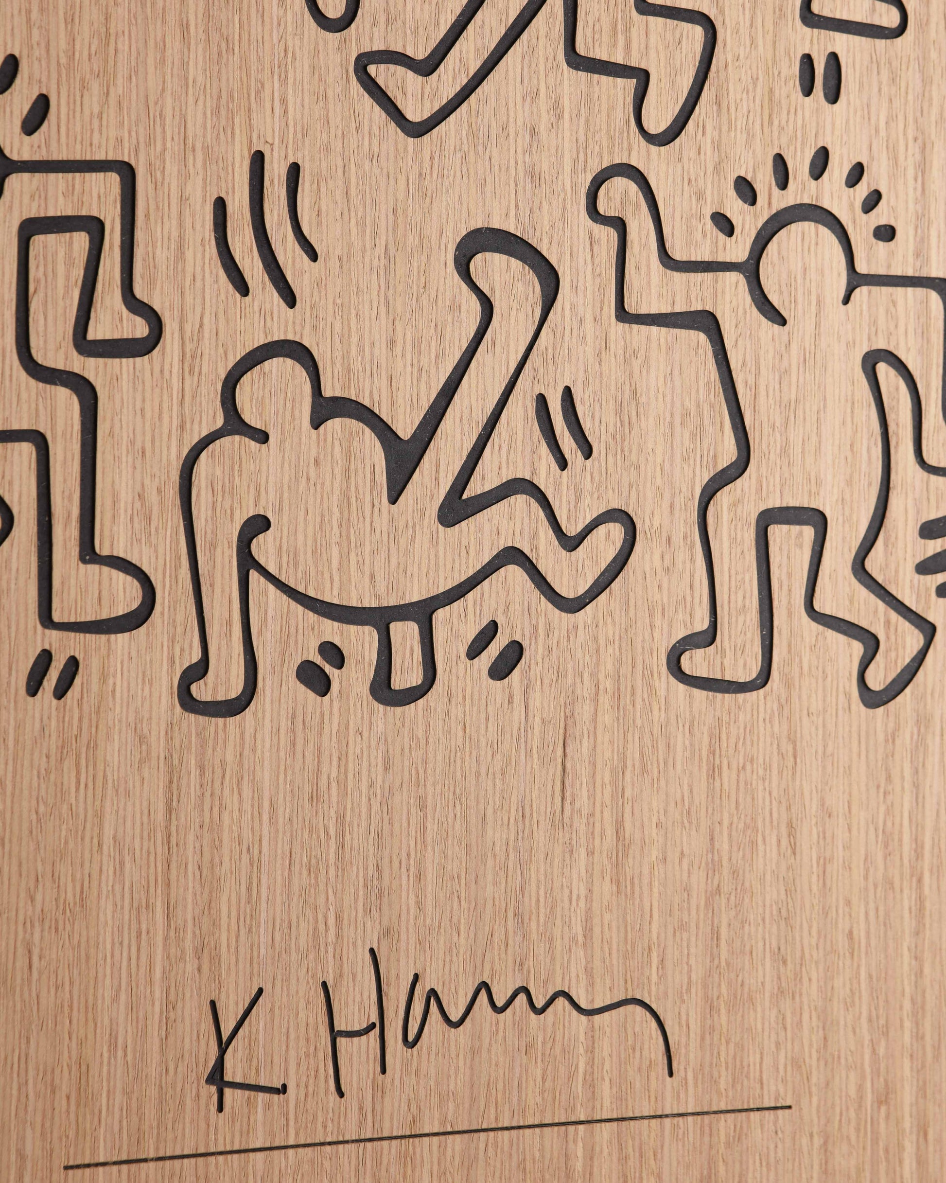 Detailed shot of the panel’s edge, showing matte black transitions against the warm oak grain and precise carving for each dancer line.