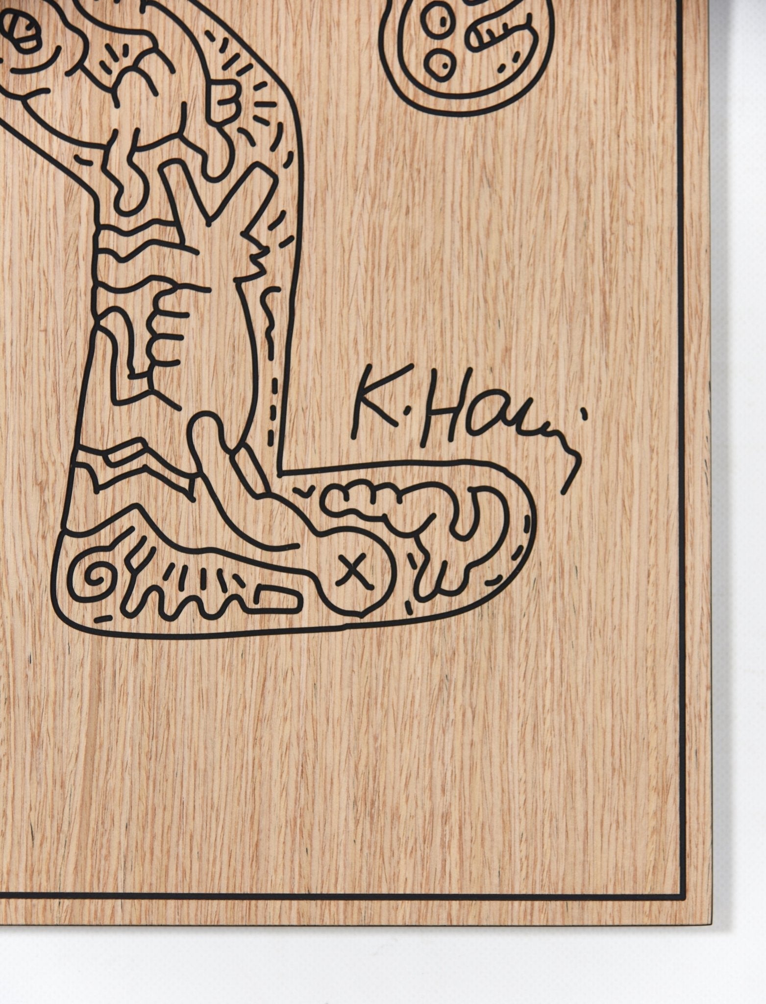 Detail of the dancer panel showing carved linework and engraved signature on oak