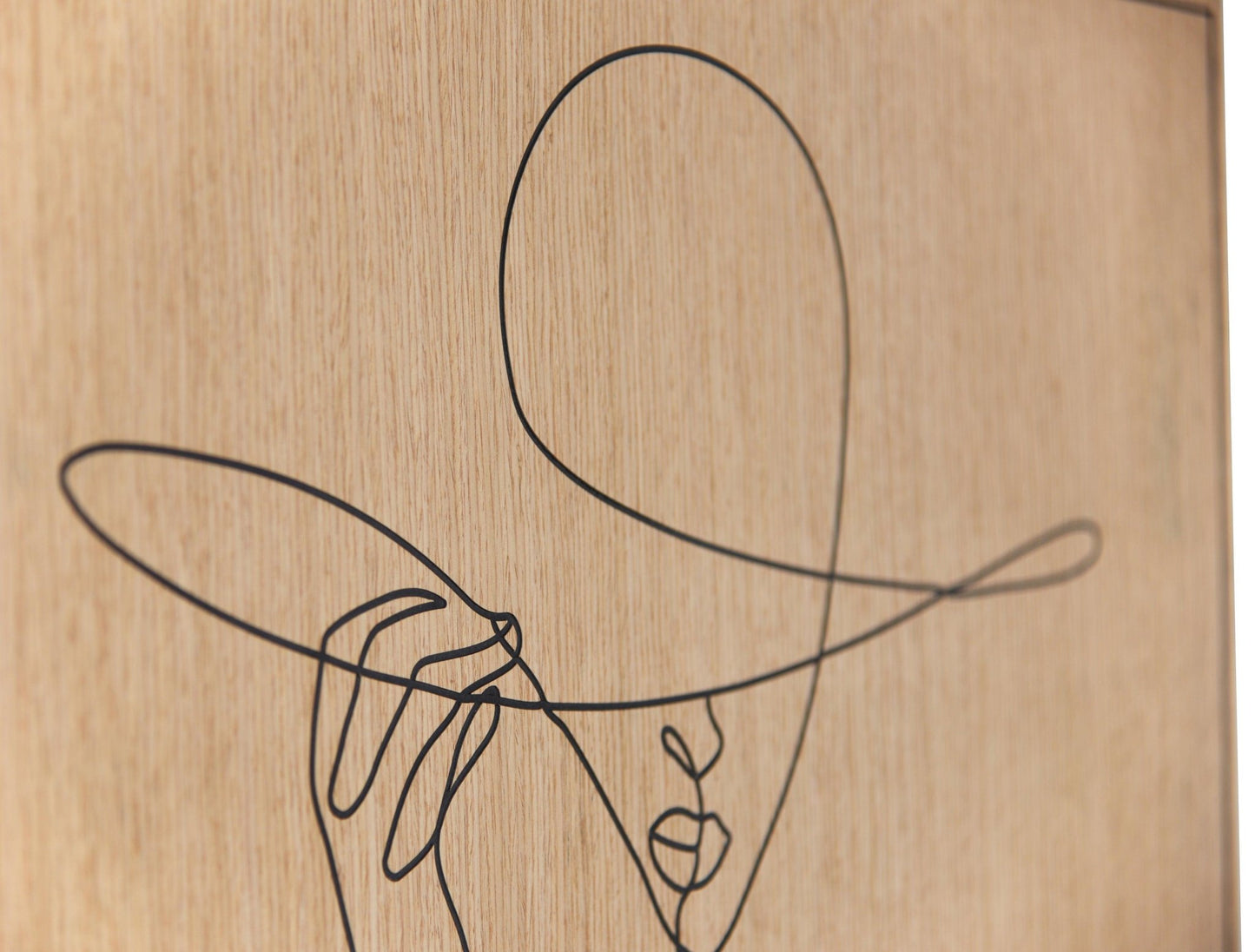 Three piece set of carved line portrait artworks in oak with dark line detail, styled above a sofa