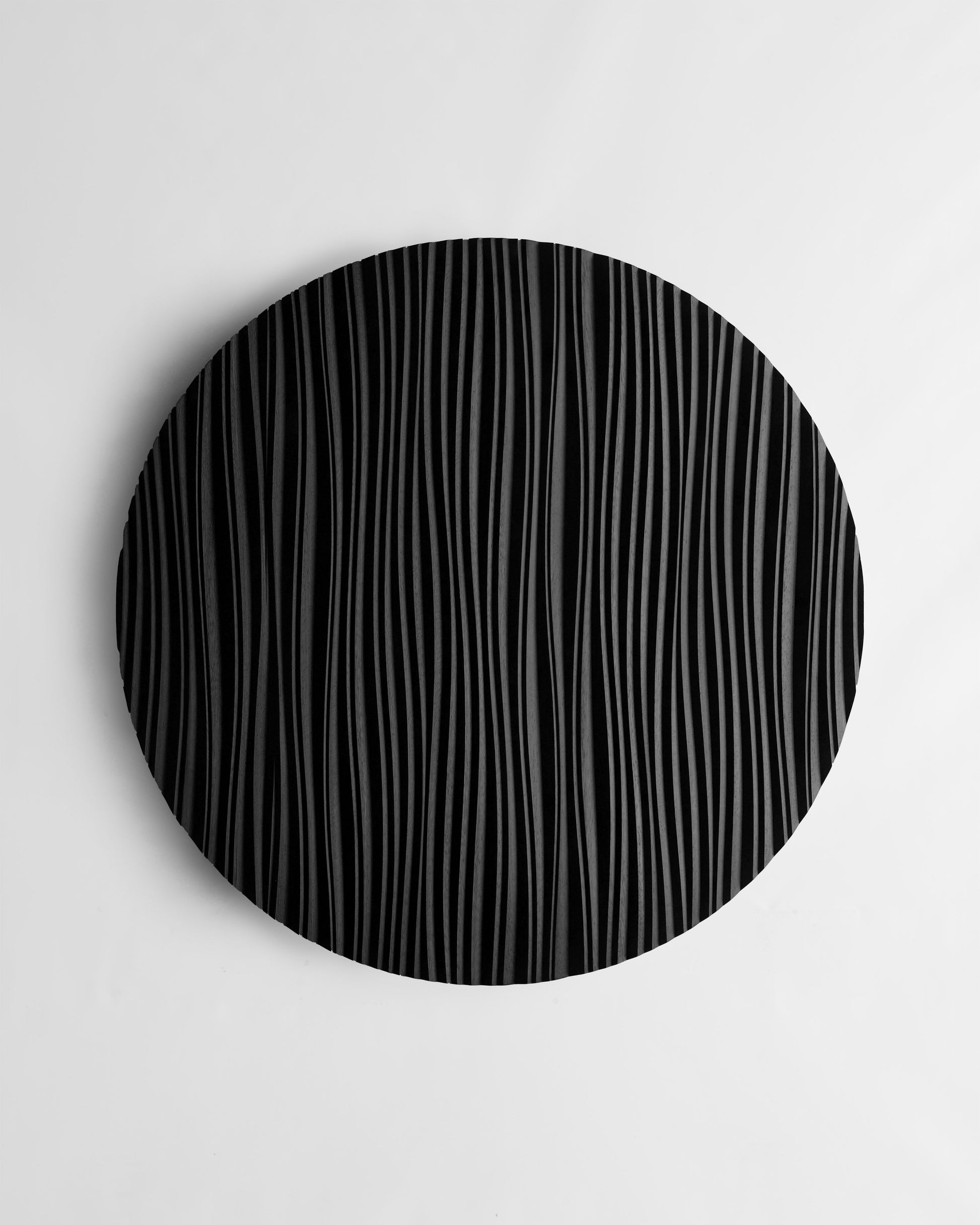 The Line round wall sculpture in black, front view on white background