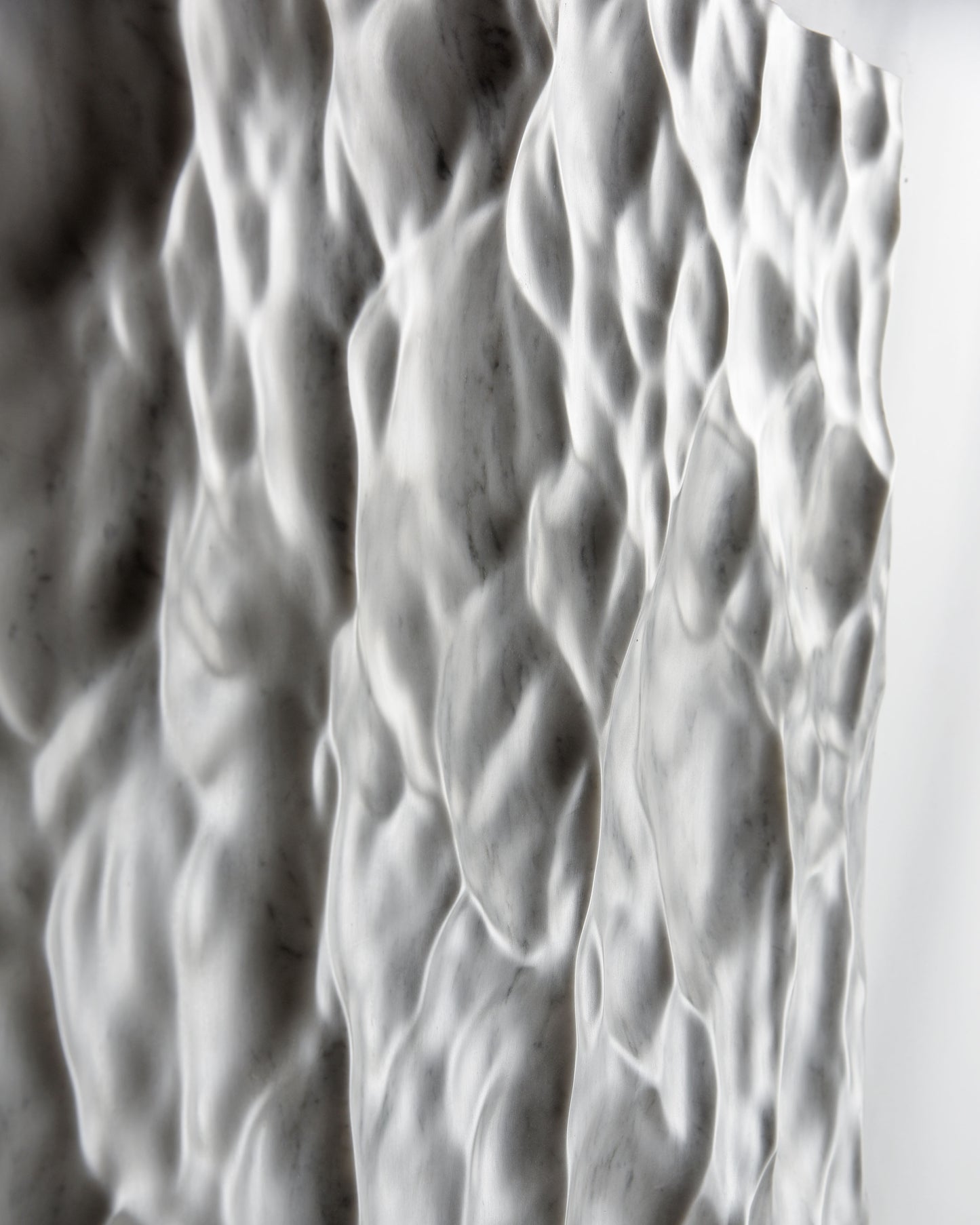 Macro view of the flowing Carrara marble texture with soft carved transitions