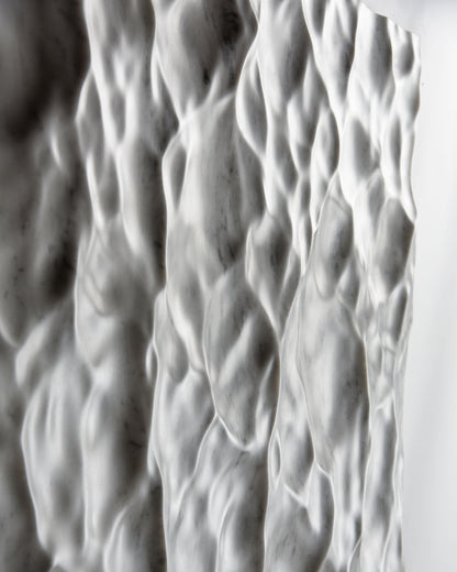 Macro view of the flowing Carrara marble texture with soft carved transitions