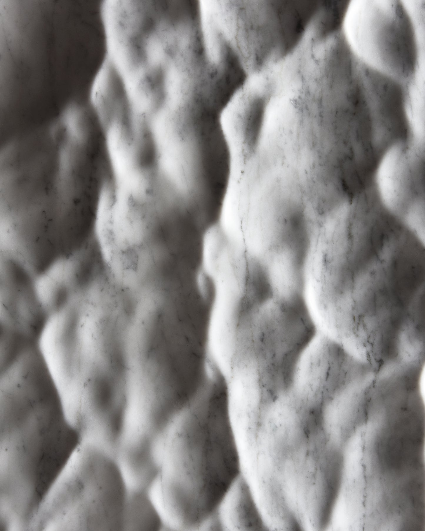 Close up of the Liquid Marble Carrara relief with soft hollows, raised forms and shifting shadows