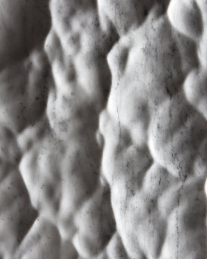 Close up of the Liquid Marble Carrara relief with soft hollows, raised forms and shifting shadows