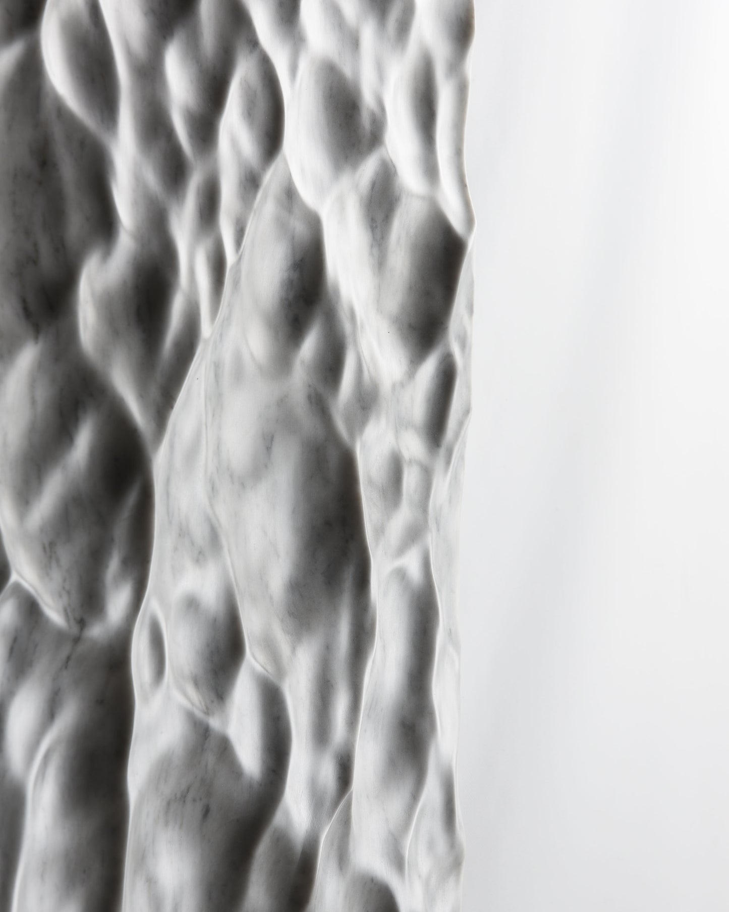 Side profile detail of the Liquid Marble sculpture showing thickness, texture and soft light