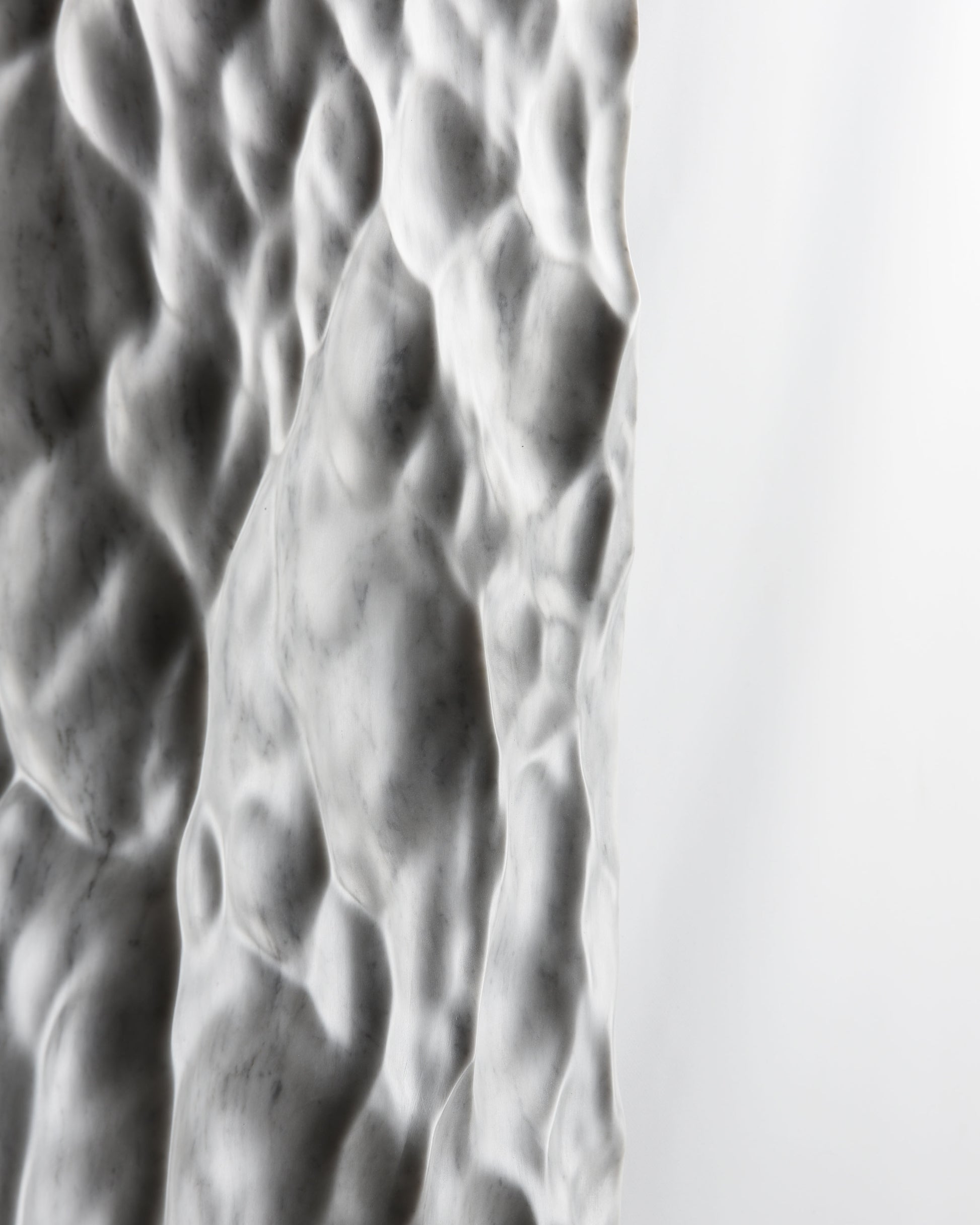 Side profile detail of the Liquid Marble sculpture showing thickness, texture and soft light