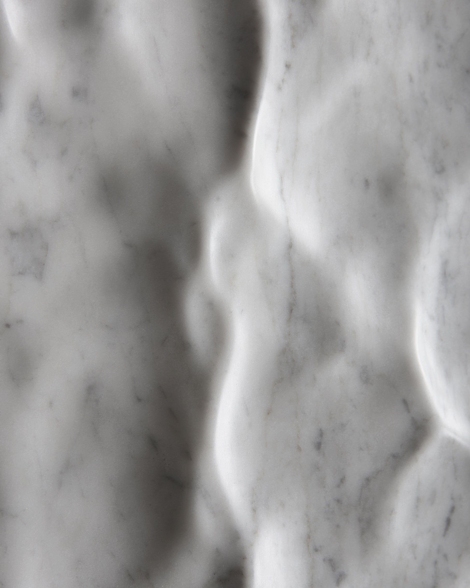 Soft macro detail of the Liquid Marble relief showing smooth depressions and hand finished texture
