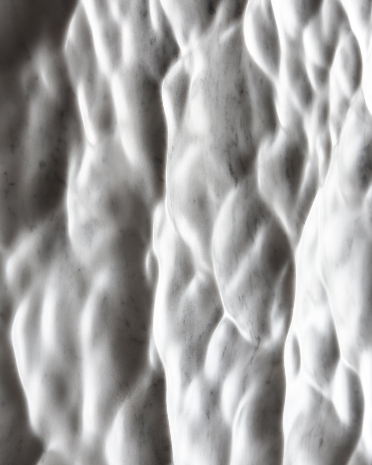 Detail of the Carrara marble surface showing depth, tactile relief and natural stone character