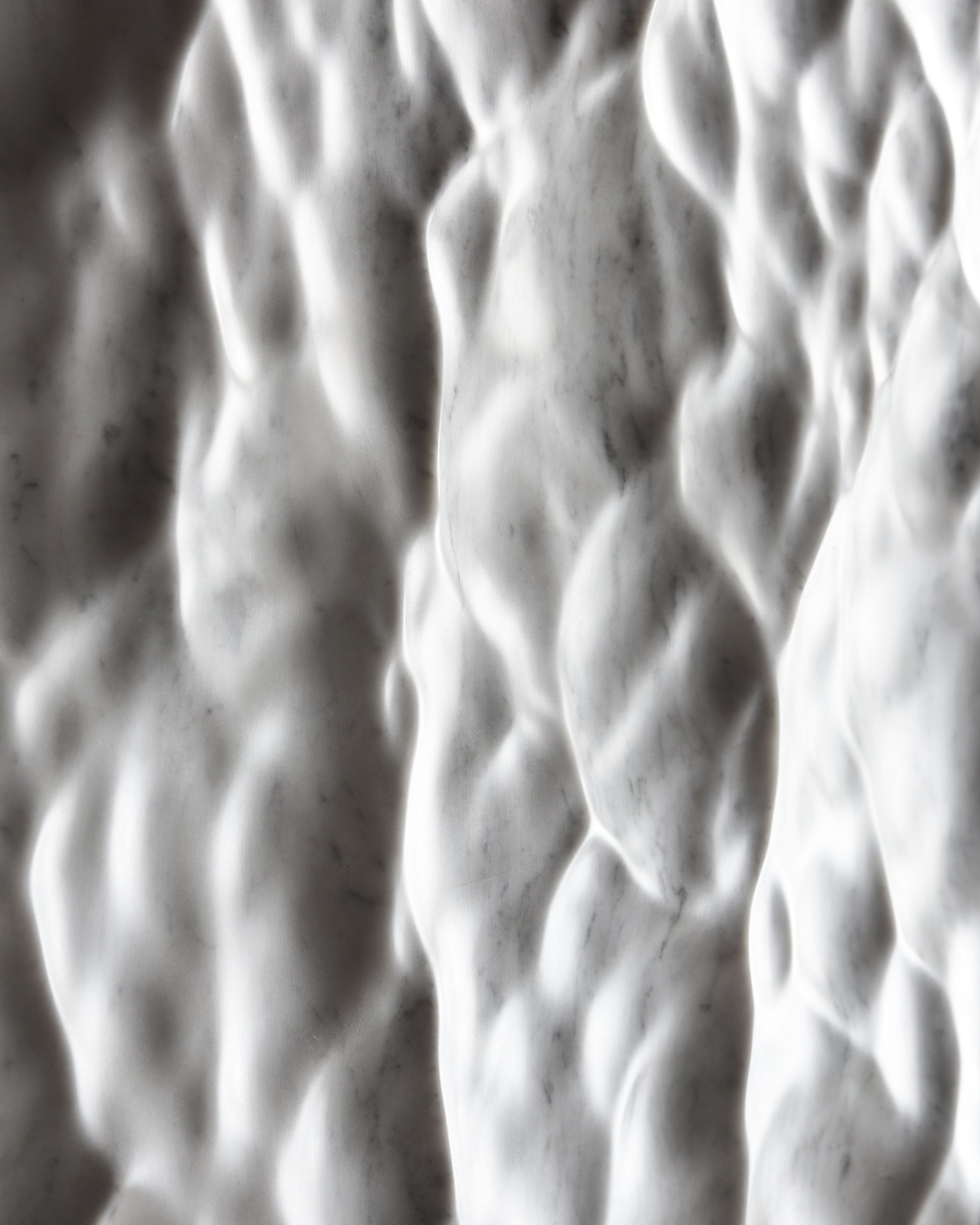Detail of the Carrara marble surface showing depth, tactile relief and natural stone character