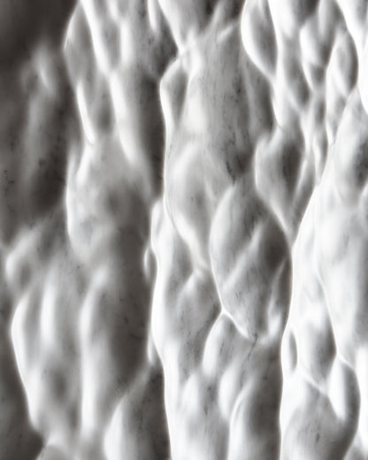 Detail of the Carrara marble surface showing depth, tactile relief and natural stone character
