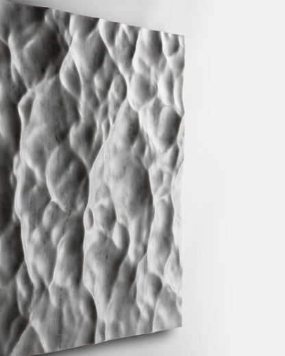 Perspective edge view of the Liquid Marble wall sculpture showing depth and wall projection