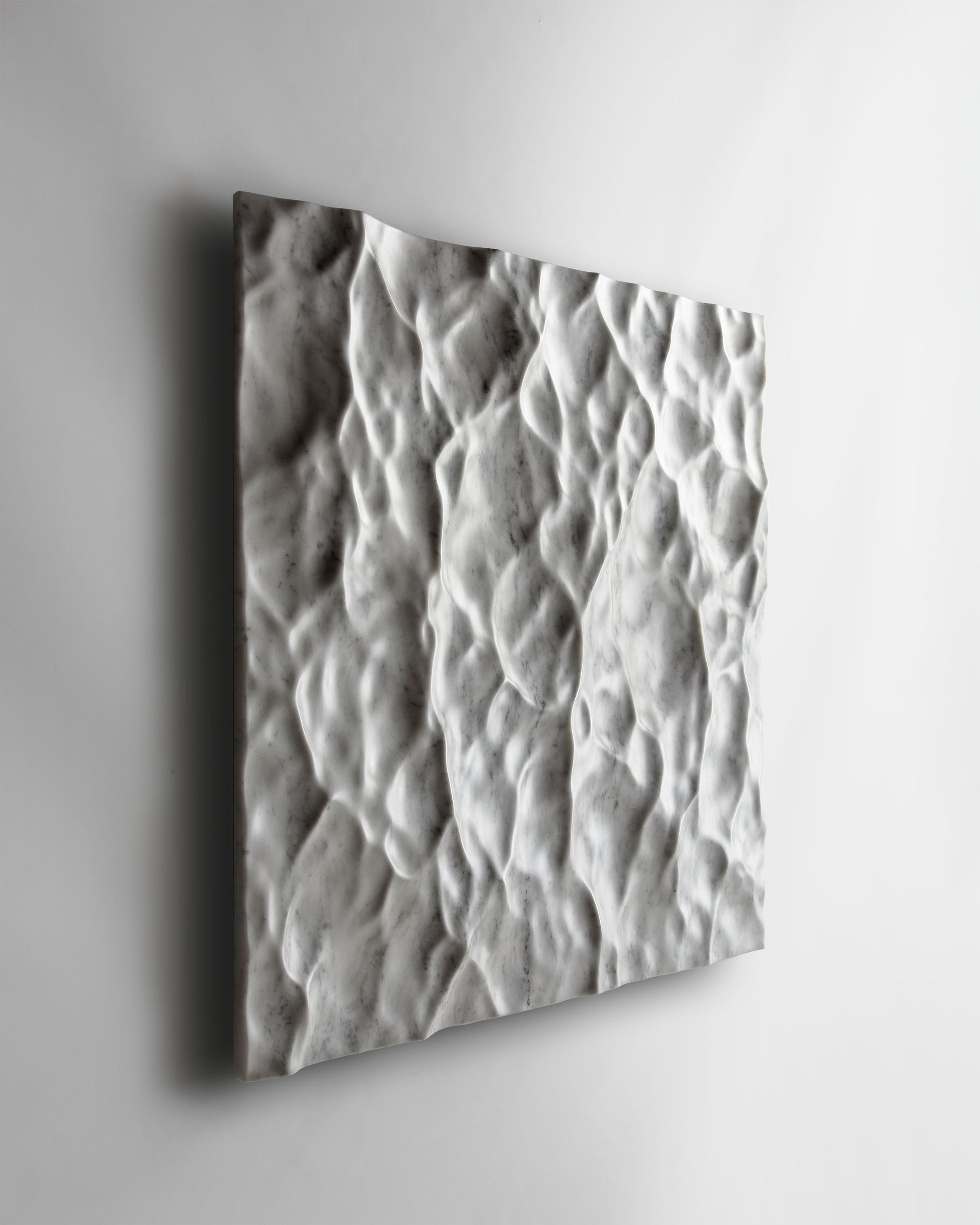 Perspective view of the Liquid Marble Carrara wall sculpture highlighting fluid movement across the surface