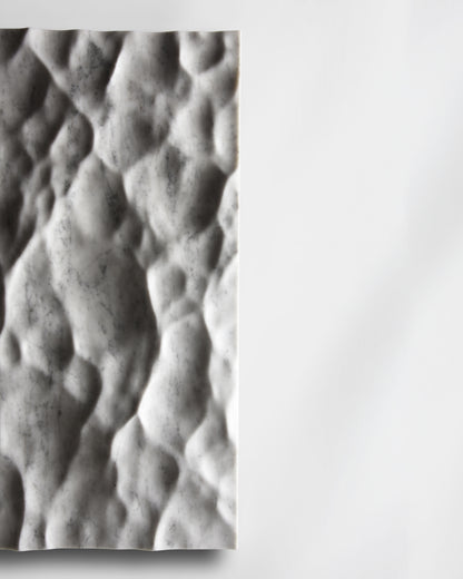 Side detail of the Liquid Marble Carrara sculpture showing edge depth and sculpted surface movement