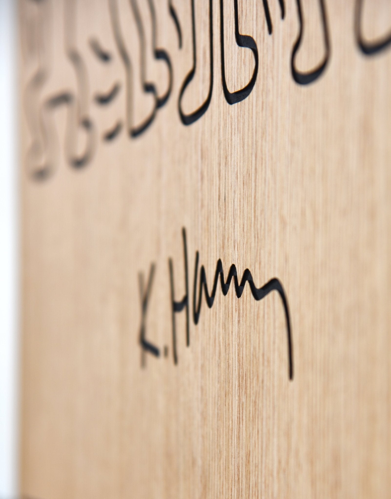 Close up of the engraved Keith Haring signature on the oak panel