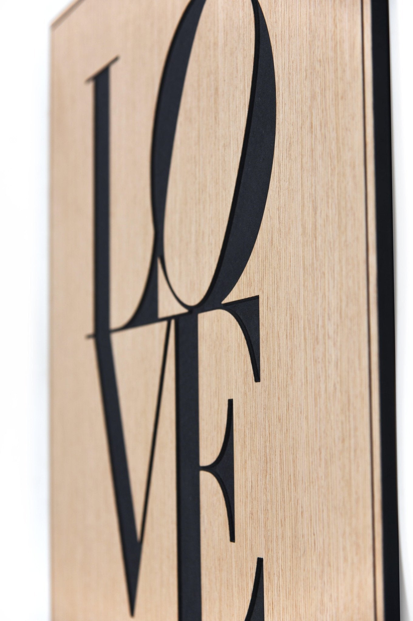 Angled close up of the Love oak artwork showing black Valchromat letter depth and clean edges