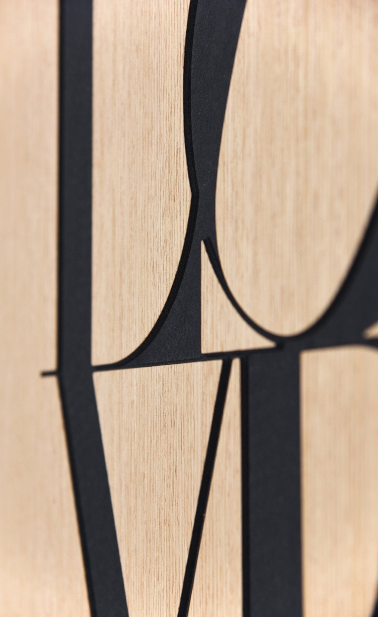 Macro close up of the black letter curves on the Love oak wall artwork