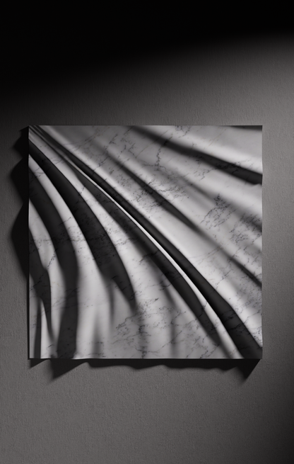 Close up of carved folds in Carrara marble showing light shadow contrast and natural veining