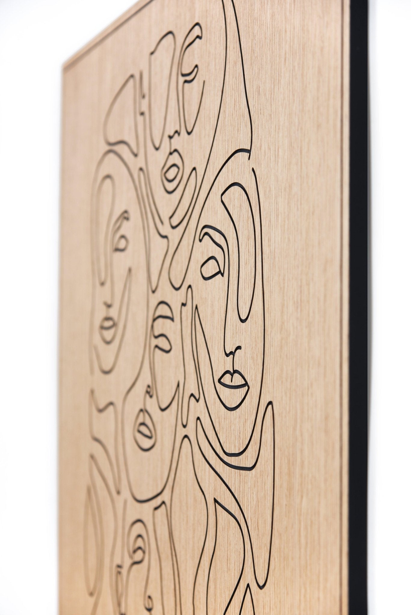 Angled close up of carved line faces on oak with dark inlay detail