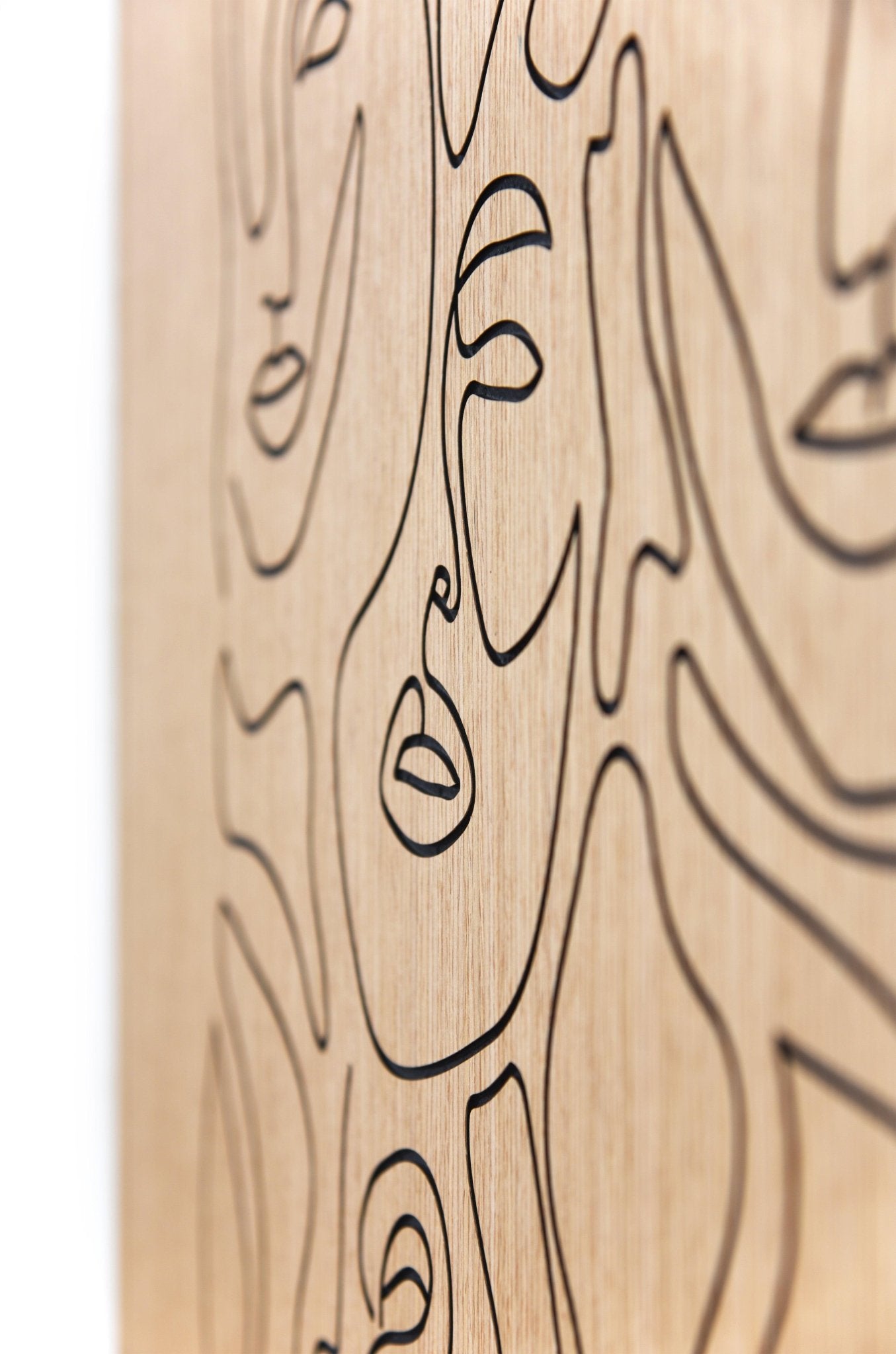Close up detail of carved facial line work on the Merging of Faces oak artwork