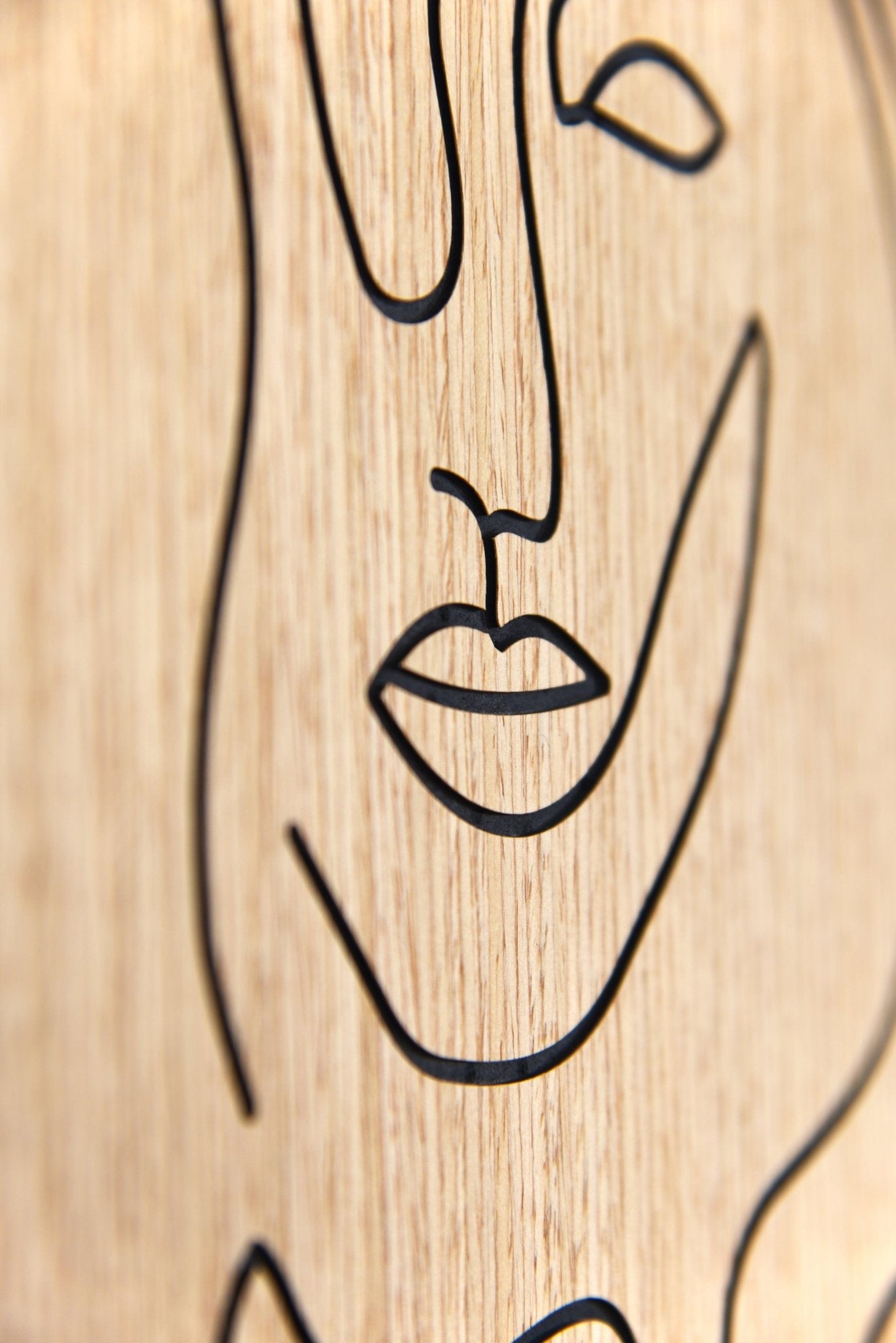 Macro detail of the carved lips line on the Merging of Faces oak wall artwork