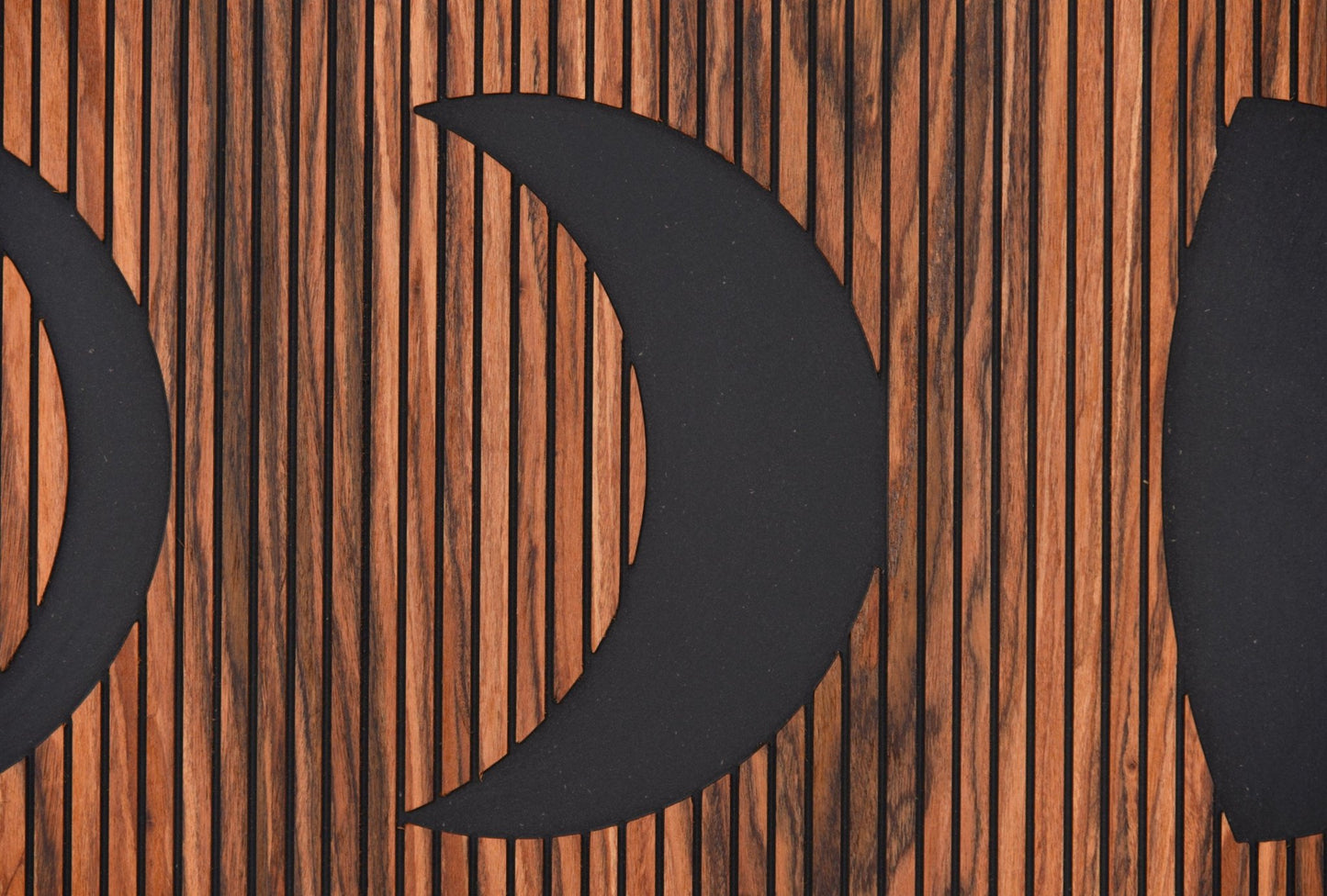 Macro detail of crescent shape and engraved line texture on rosewood