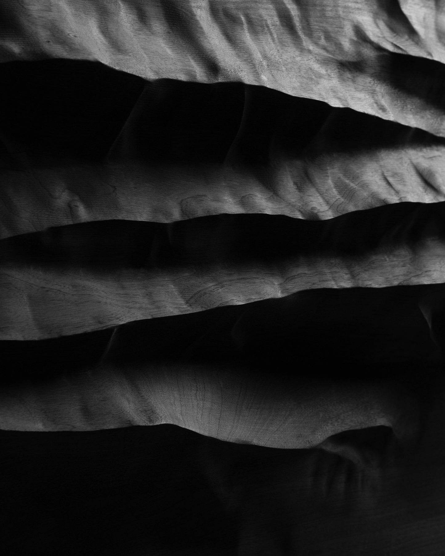 Close view of the carved mountain inspired relief and shadowed cavities of Mountain Echo Black