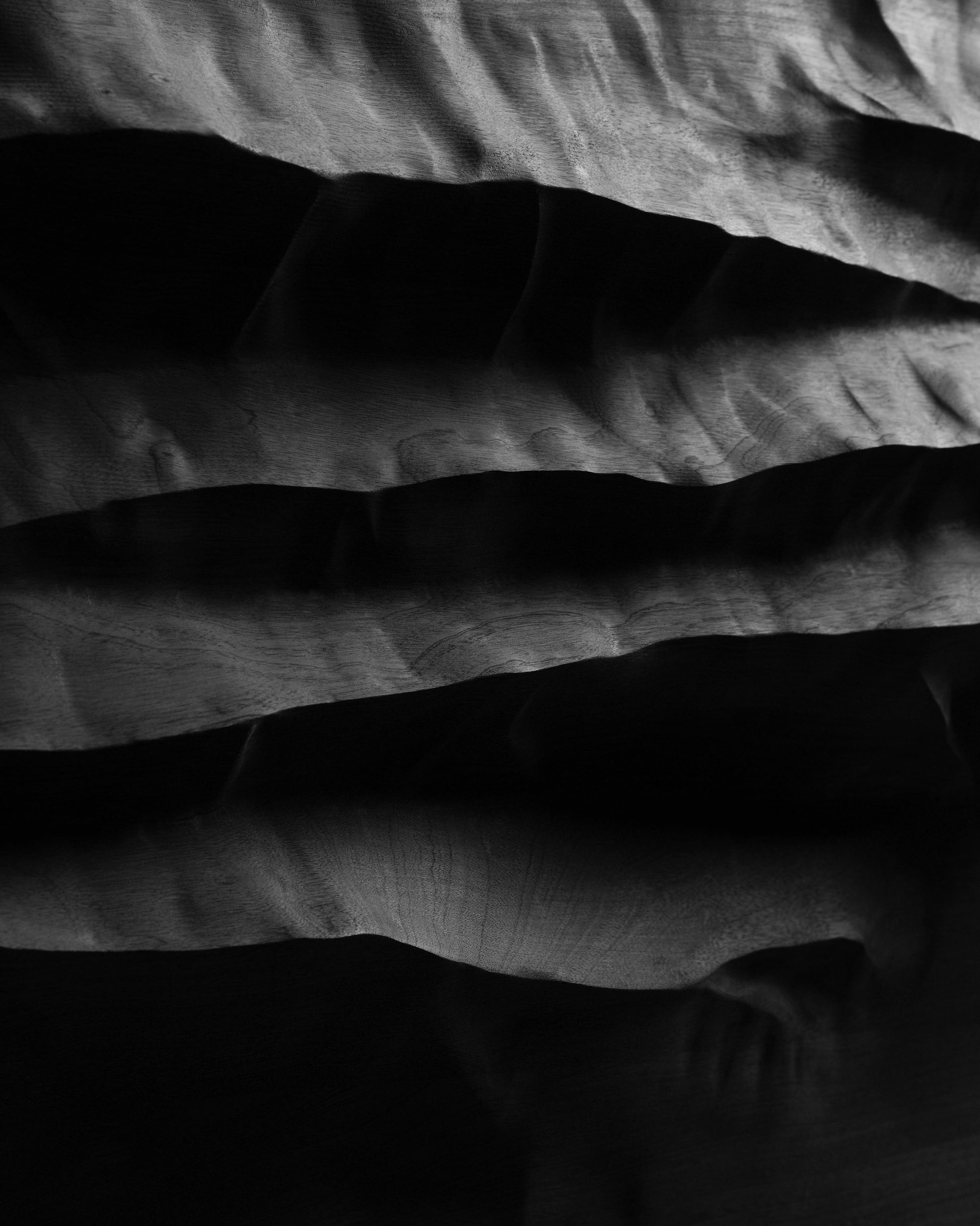 Close view of the carved mountain inspired relief and shadowed cavities of Mountain Echo Black