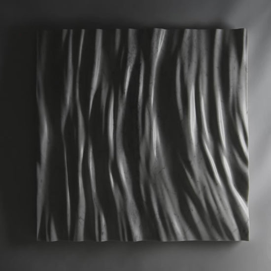 Video showing the Eternal Carrara marble wall sculpture with dramatic light and shadow across the folds